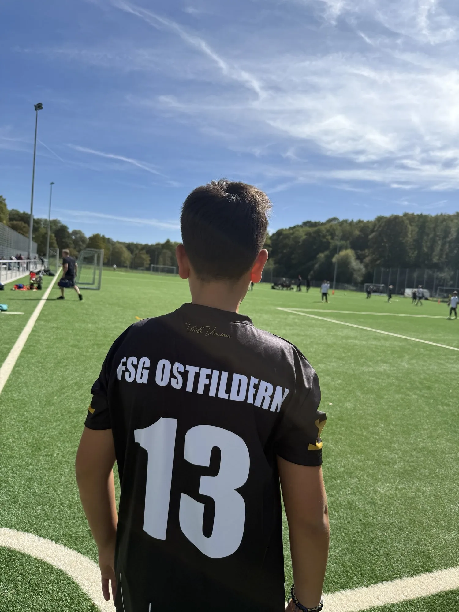 Spieler von hinten im Trikot der FSG Ostfildern mit der Rückennummer 13 am Spielfeldrand